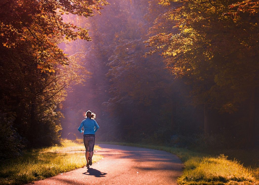 Coureur de trail en tenue de course sur un sentier, jambes en plein effort