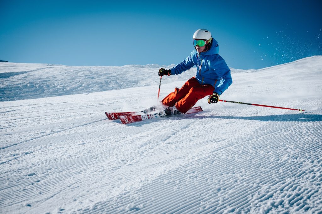 Skis alpins, chaussures et bâtons alignés au pied des pistes enneigées en station