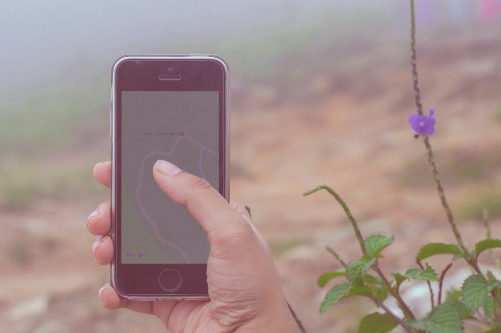 Randonneur consultant une application de cartographie sur son smartphone lors d’une randonnée en montagne