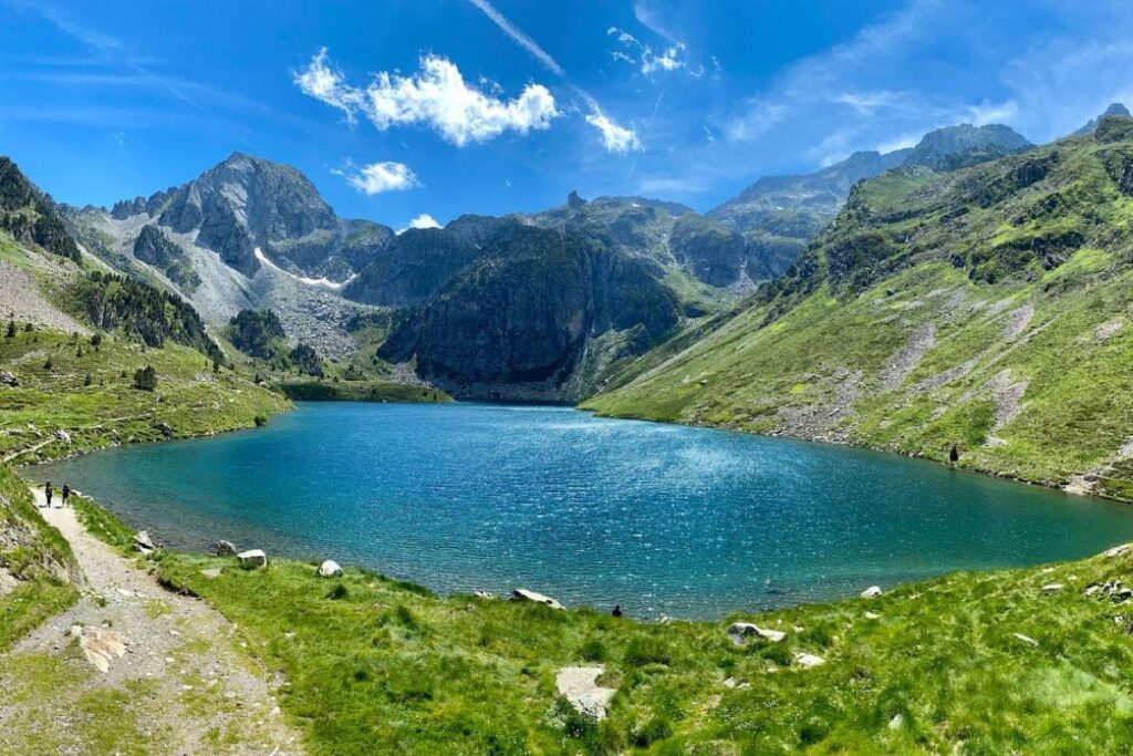 Sentier de randonnée longeant le gave d’Ilhéou dans une vallée verdoyante des Hautes-Pyrénées