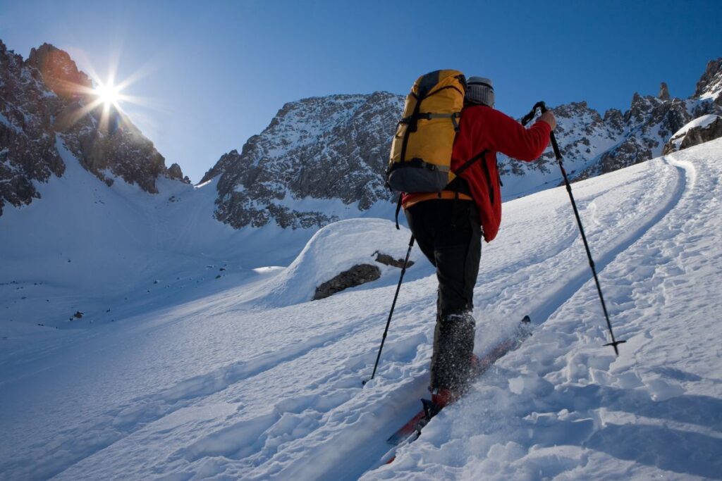 Skieurs de randonnée en montée avec peaux de phoque sur une pente enneigée des Alpes