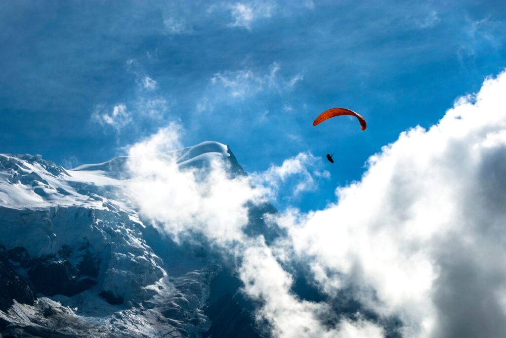 Parapente biplace en vol face au massif du Mont-Blanc au-dessus de Chamonix