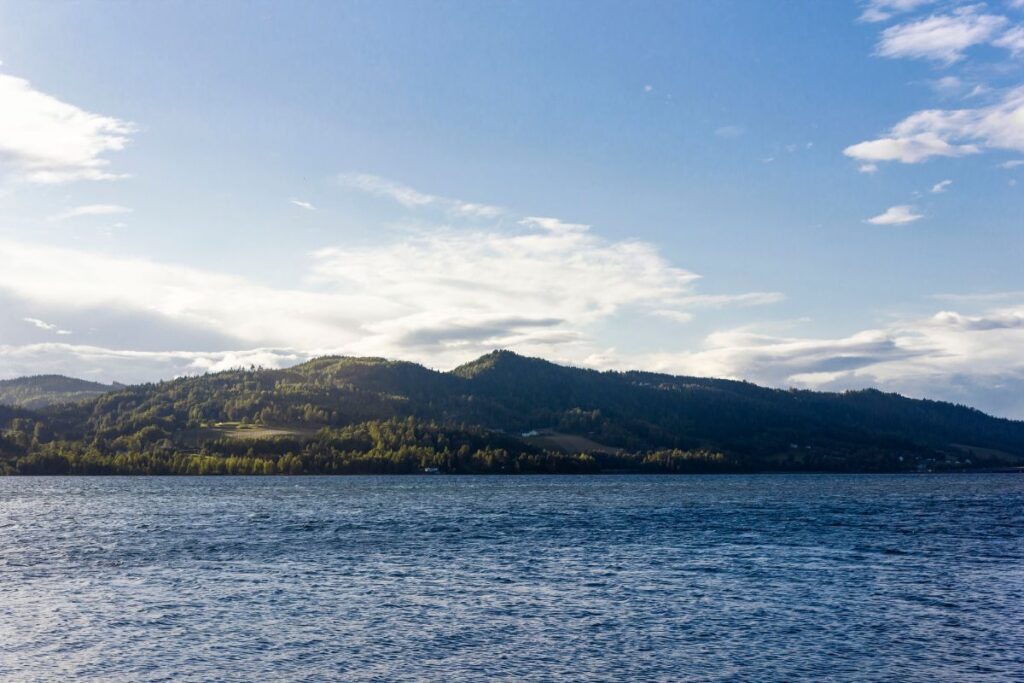 Lac Mjøsa bordé de collines boisées et de terres agricoles en Norvège centrale