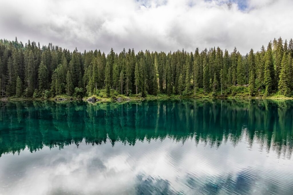 Lac de Carezza aux eaux vertes et bleues devant les tours du Latemar dans les Dolomites