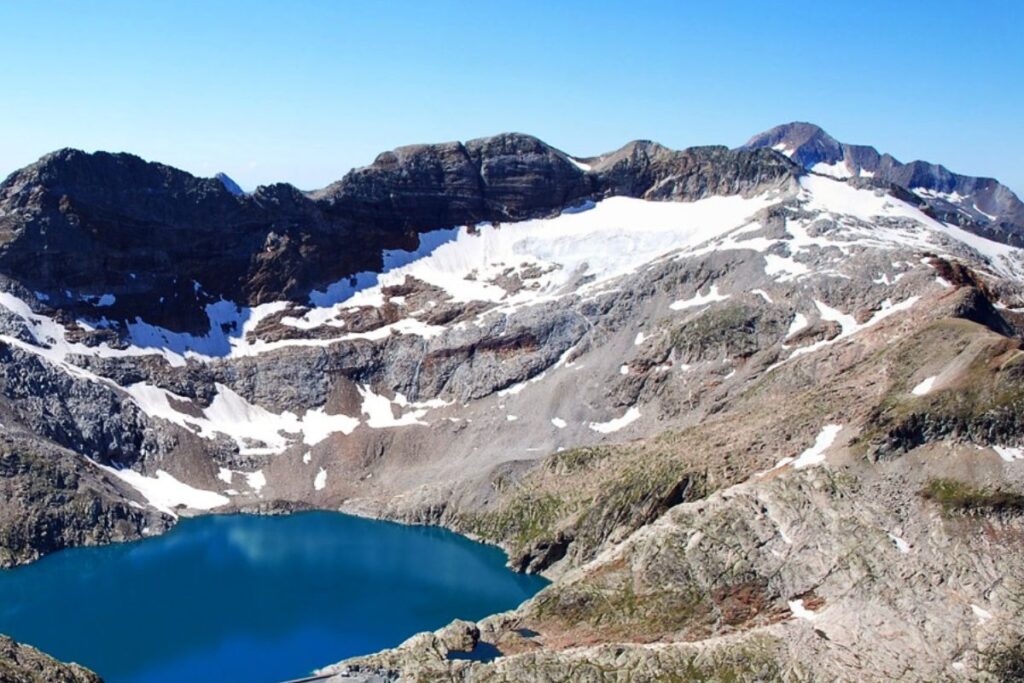 Lac du Portillon aux eaux sombres dans un cirque minéral de haute montagne, massif de Luchon