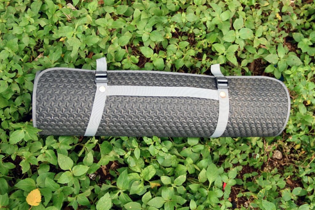 Matelas de camping en mousse et matelas gonflable posés sur l’herbe