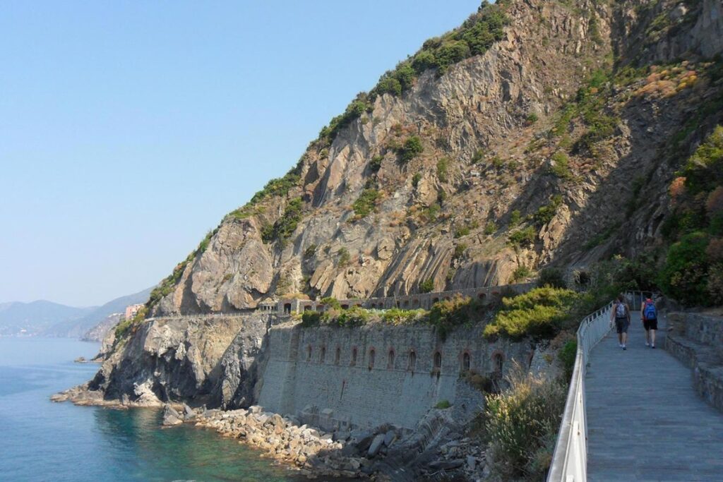 Sentier en balcon au-dessus de la mer et d’un village coloré des Cinque Terre, en Ligurie
