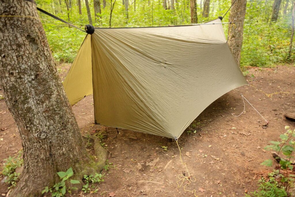 Tarp de randonnée tendu avec des bâtons de marche pour un bivouac léger