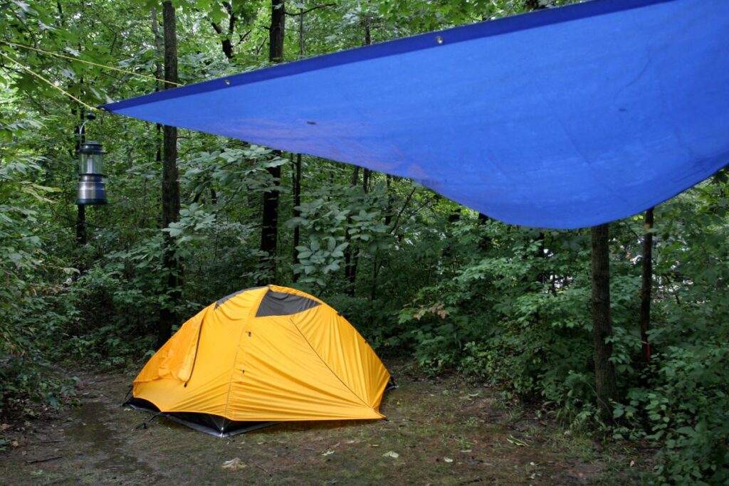 Tente de randonnée classique et tarp léger installés côte à côte au bivouac