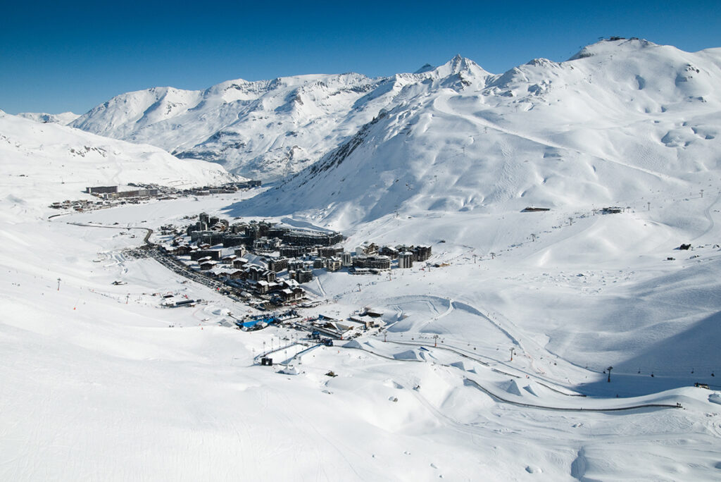Chalet de montagne enneigé en bordure de piste dans une station des Alpes