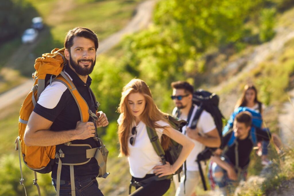 Randonneur contemplant un paysage de montagne depuis un sentier en crête