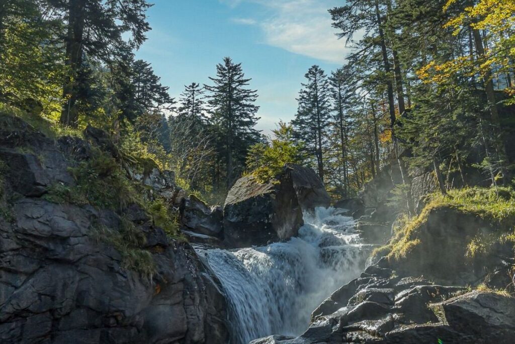 Cascade du Cerisey tombant entre les rochers et les sapins sur le chemin des cascades de Cauterets