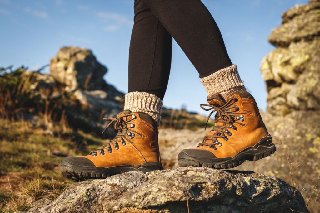 Chaussures de montagne à tige haute et semelle crantée posées sur un rocher en altitude