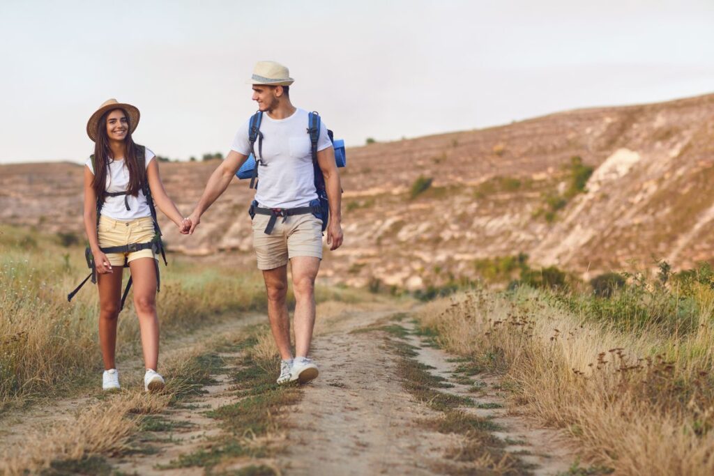 Couple de randonneurs avec sacs à dos marchant sur un sentier de montagne