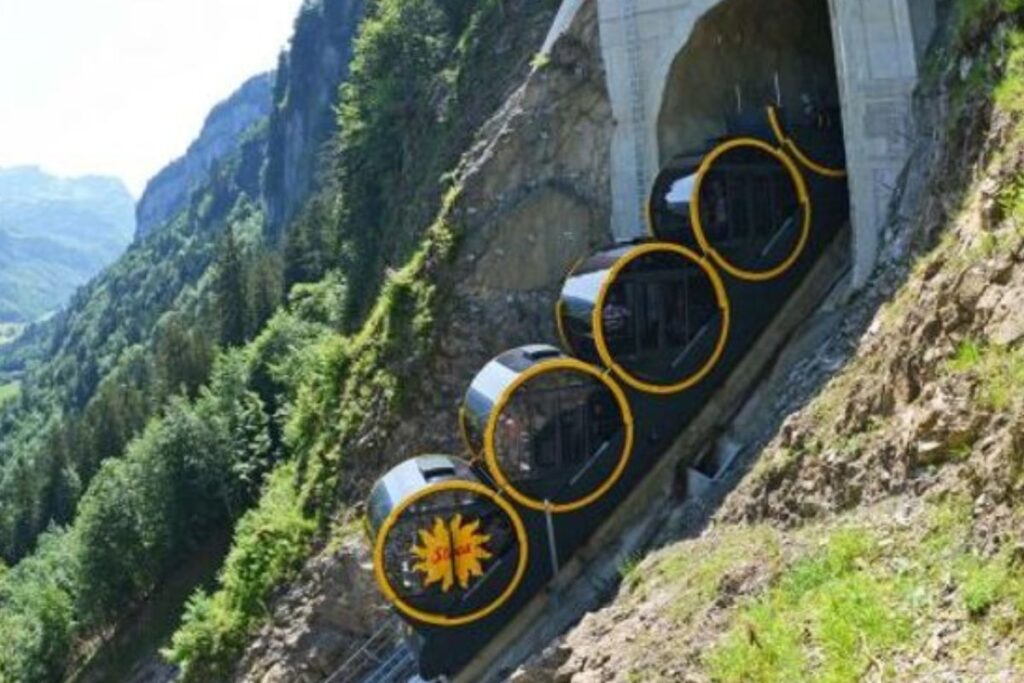 Voie du funiculaire de Stoos montant à flanc de montagne avec la vallée de Schwyz en contrebas