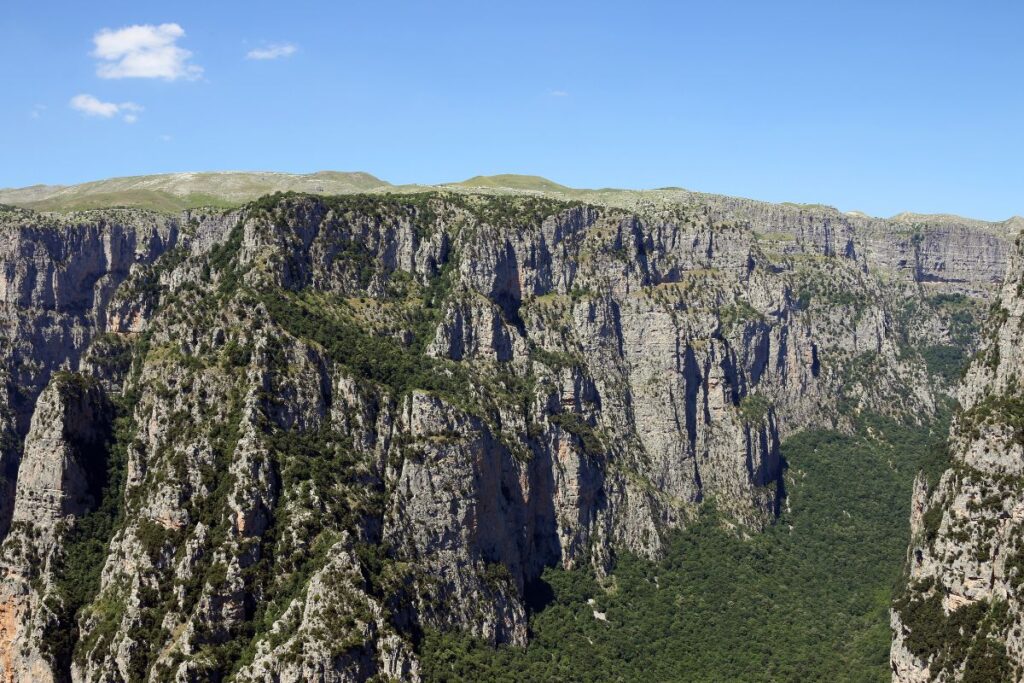 Sentier de randonnée au fond des gorges de Vikos, entre forêt et lit rocheux du Voïdomatis