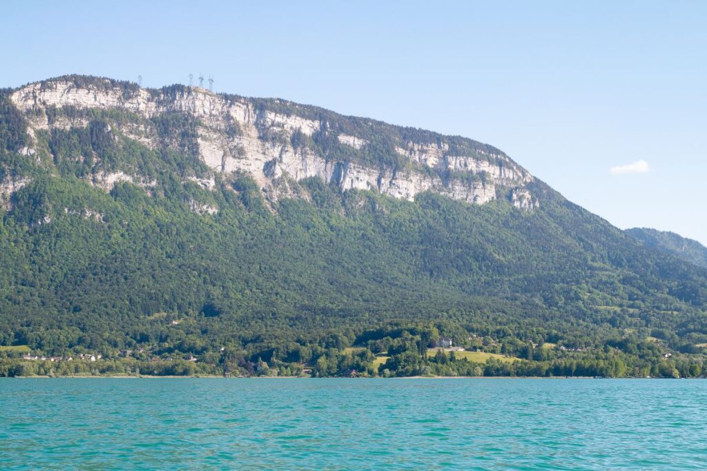 Vue d’ensemble du lac d’Aiguebelette et de ses eaux turquoise au pied de la montagne de l’Épine, en Savoie