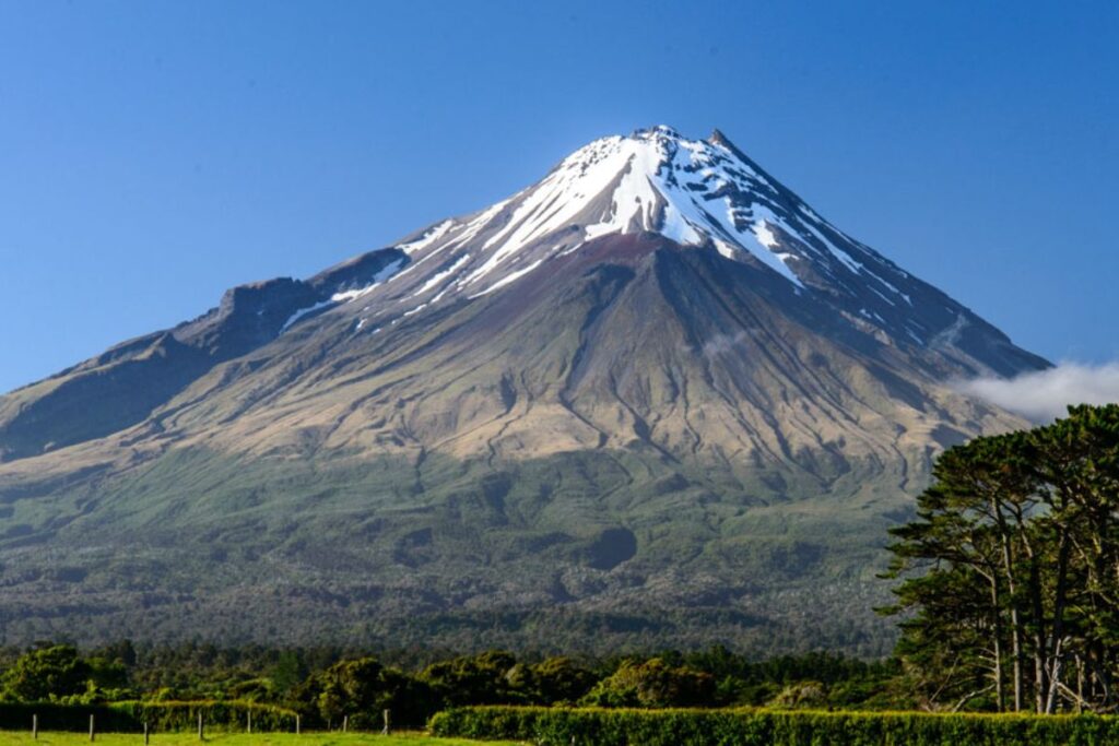 Sentier de randonnée sur les pentes du mont Taranaki avec vue sur le sommet volcanique