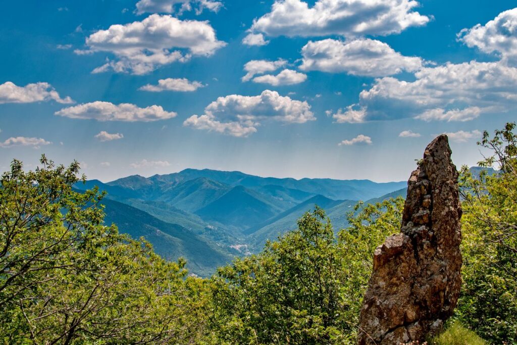 Chemin de terre traversant les collines boisées et les hameaux des Cévennes sur le GR70