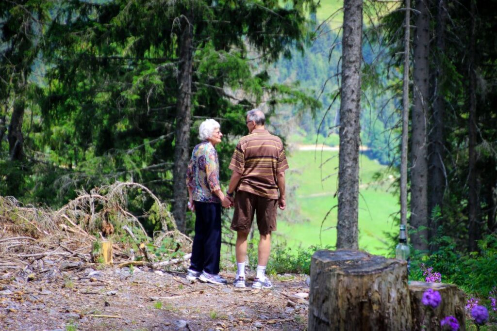Randonneur senior préparant son sac à dos et ses bâtons avant une randonnée itinérante