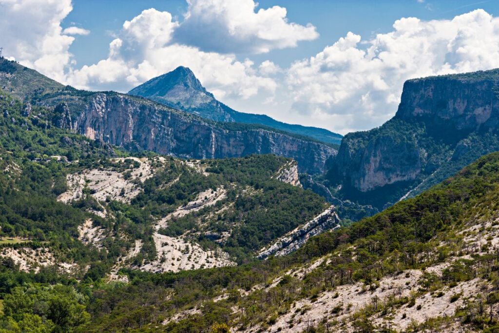 Randonneur sur une crête calcaire dominant une vallée des Alpes-de-Haute-Provence