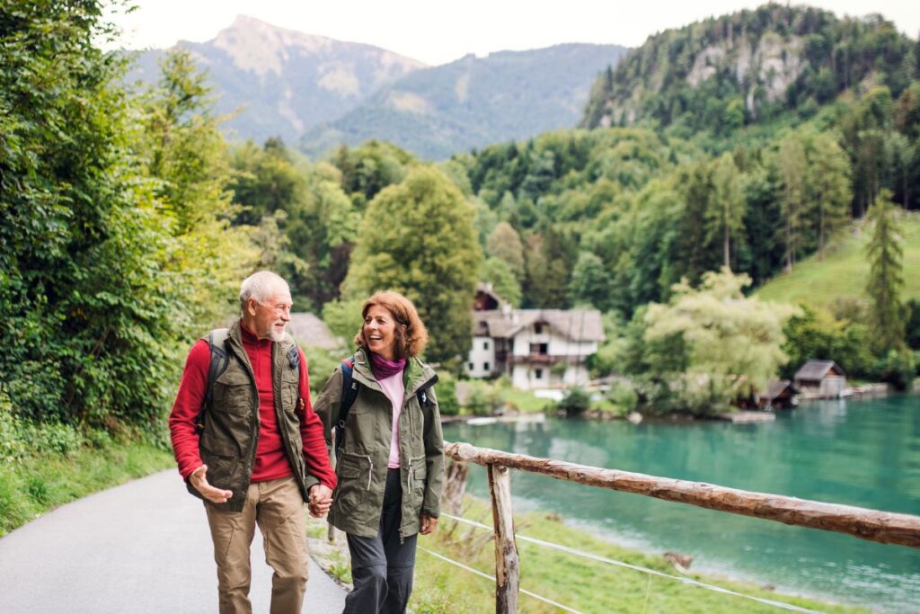 Couple de randonneurs seniors marchant sur un sentier de campagne avec des bâtons