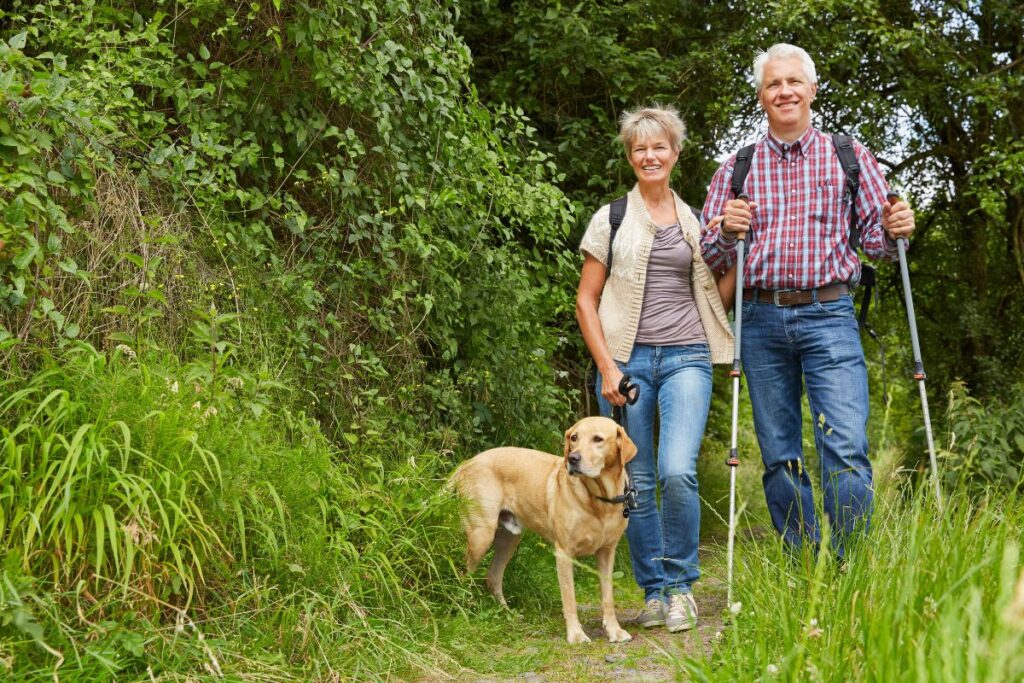 Randonneuse senior avec bâtons de marche sur un chemin de montagne
