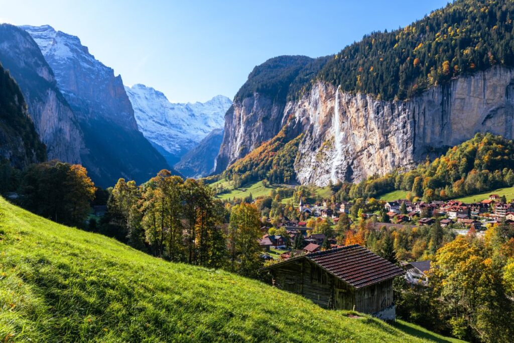 Vallée de Lauterbrunnen entre ses falaises calcaires, avec une cascade tombant de la paroi et les chalets du village
