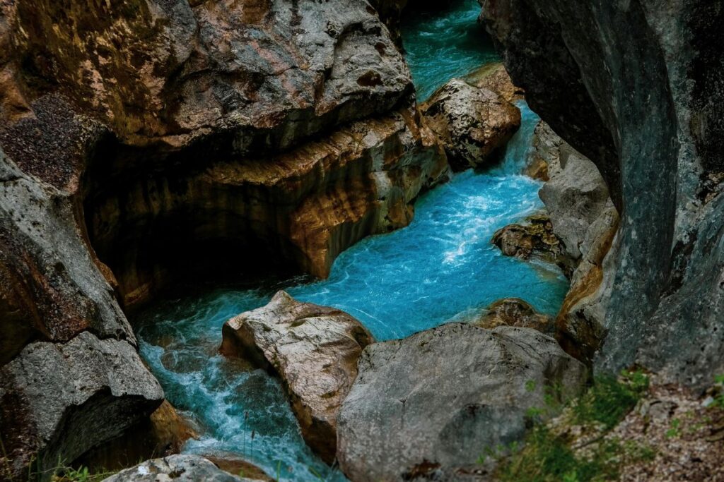 Rivière Soča aux eaux turquoise coulant entre des galets blancs dans la vallée de la Trenta