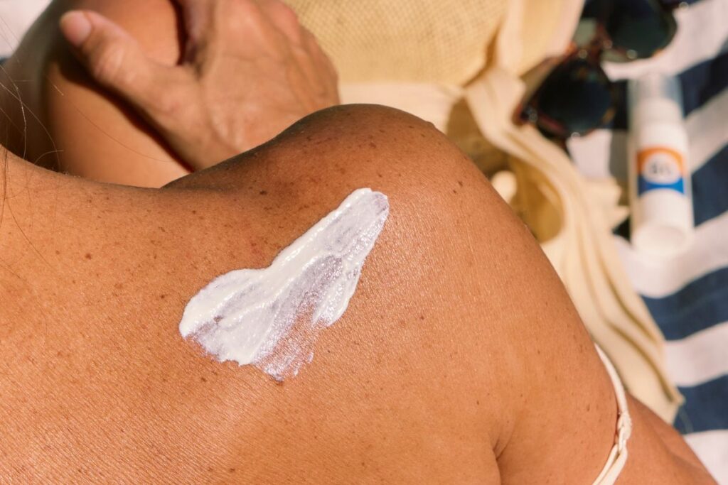 Tube de crème solaire et flacon de répulsif posés sur un sac de randonnée