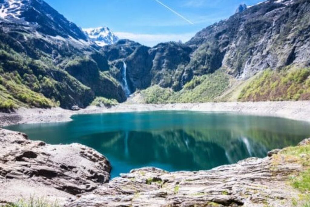 Rives du lac d’Oô et refuge au pied des montagnes pyrénéennes