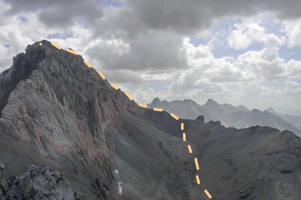 Randonneur progressant dans les éboulis et les dalles calcaires sous le col des Houerts, Haute-Ubaye