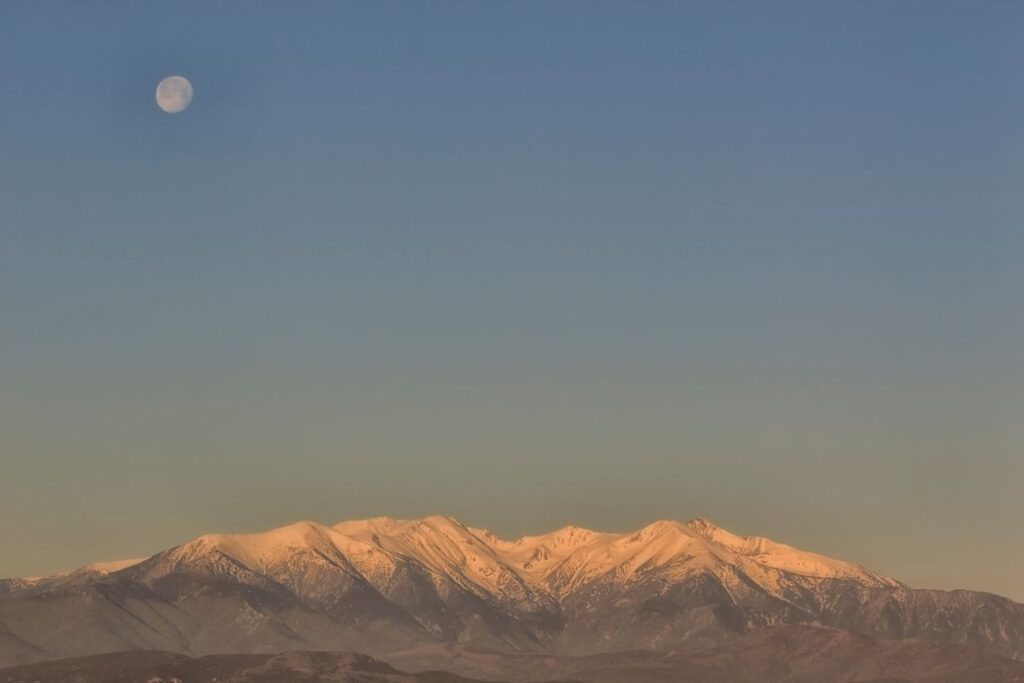 Lever de soleil depuis le sommet du Pic du Canigou, lumière dorée sur les crêtes des Pyrénées-Orientales
