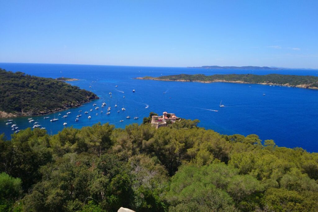 Crique aux eaux turquoise bordée de pins sur l’île de Port-Cros, dans le Var