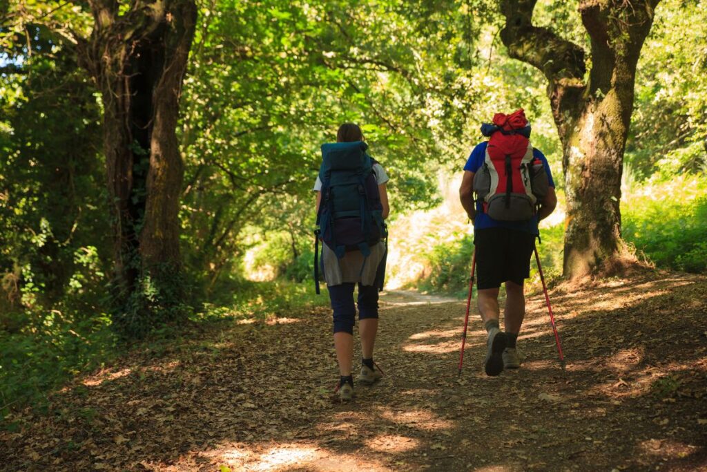 Marcheur s’entraînant avec sac à dos sur un sentier vallonné avant le chemin de Compostelle