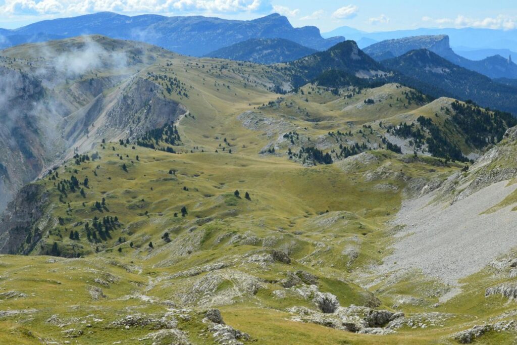 Randonneur sur une crête rocheuse face au paysage de montagnes des Baronnies provençales