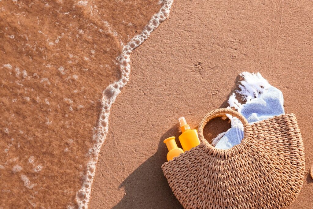 Tubes et stick de crème solaire SPF 50 posés sur un sac à dos de randonnée