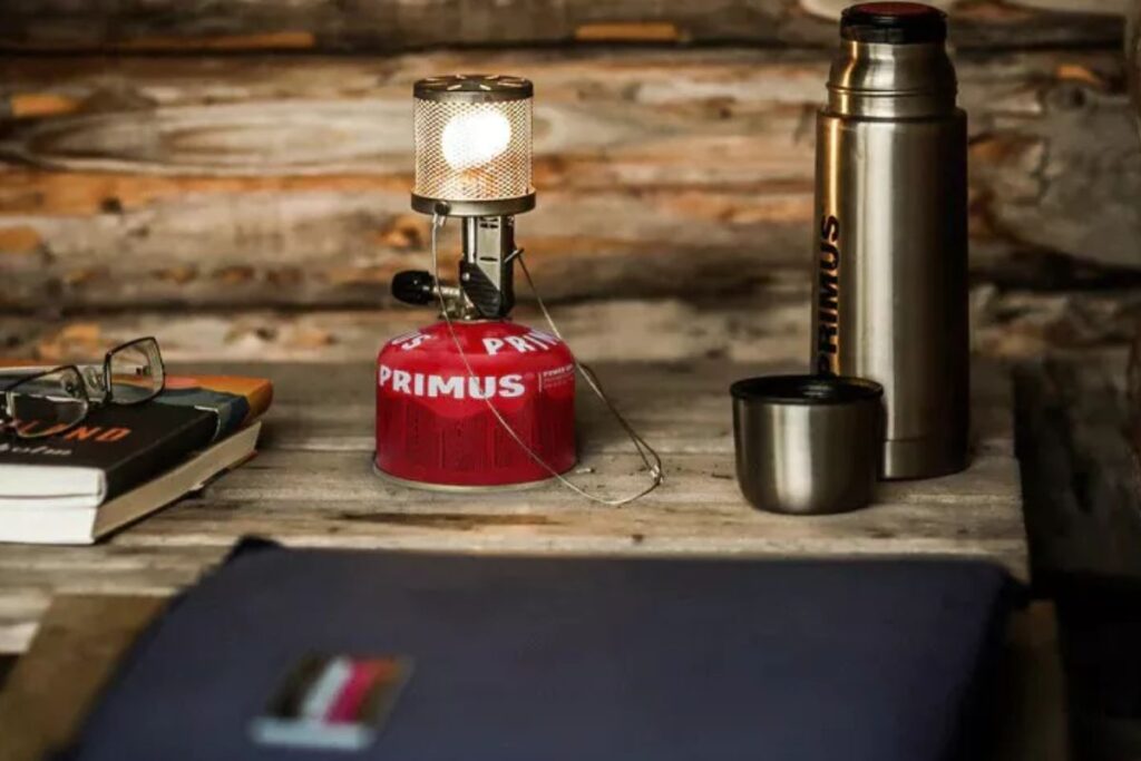 Mini-réchaud à gaz vissé sur une cartouche avec une petite casserole au bivouac
