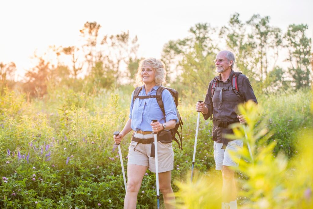 Randonneurs seniors équipés de bâtons de marche sur un sentier de montagne