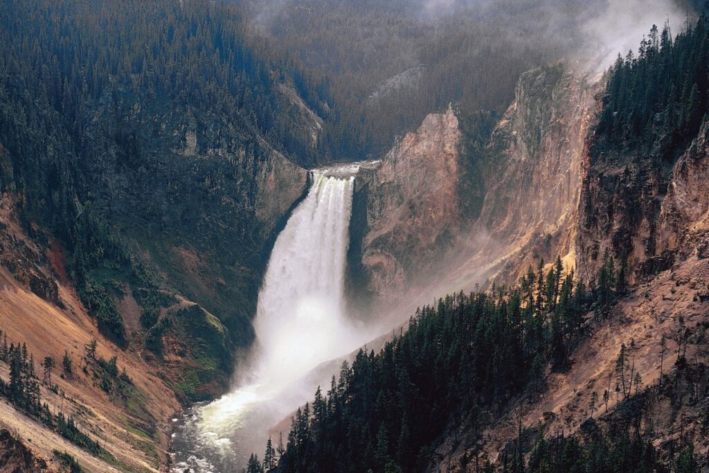 Randonneurs sur une passerelle en bois au-dessus d’un bassin géothermique de Yellowstone