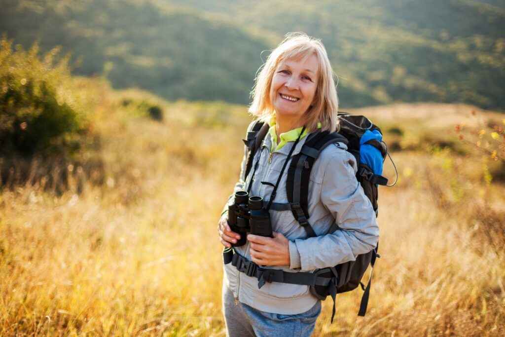 Femme senior en tenue de sport marchant sur un sentier plat en forêt